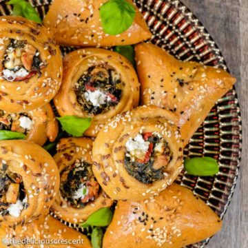 Several Swiss chard and feta pies (fatayer) served on a plate.