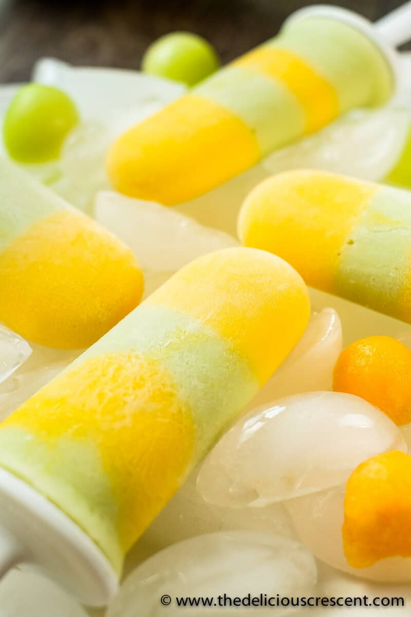 Close view of fruit pops arranged over ice in a plate.