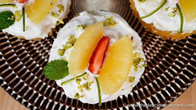Pineapple cupcakes made with fresh cream and yogurt are amazingly delicious. These cute homemade cupcakes have an easy decoration concept and would be a great party idea for kids. This recipe made from scratch allows you to use thick Greek style yogurt to lighten up a traditional favorite, enhancing the nutrition, and is still absolutely delicious. Try this sweet treat this holiday season. #cupcakes #pineapplecake Close up shot of the Pineapple cupcake.