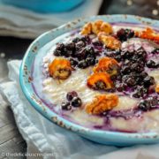 Barley porridge with blueberries, walnuts, dates and honey served in a bowl.