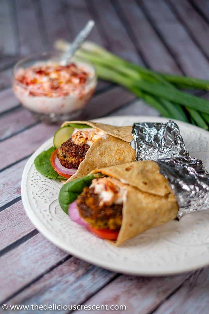 Indian fish cakes (fish shami kabab) crispy outside, soft in the center, these richly flavored spicy patties are a terrific appetizer. Easy, healthier, low carb and made with salmon. Freezes beautifully! Gluten free option. #salmon #appetizer #lowcarb #easyrecipe #freezercooking #fish #snacks Spicy salmon patty wraps served on a plate