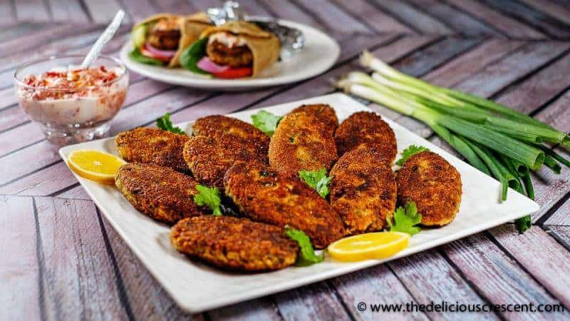 Indian style fish patties served on a plate with a dip.