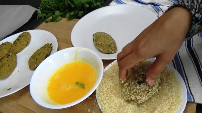 Rolling the Indian fish cakes in bread crumbs
