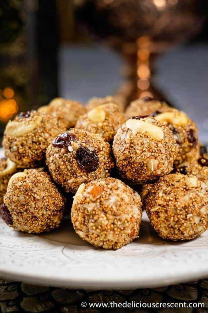 Amaranth energy balls with dates and cashew butter are no bake gluten free energy balls that are so delicious. These are perfect for a snack to give you a boost of energy or a great dessert-like energy bite. This healthy snack is low-carb, gluten-free, vegetarian, freezer friendly and easy to make. #thedeliciouscrescent #energyballs #healthysnacks #nobake Amaranth energy balls with dates served on a white plate