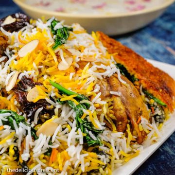Persian saffron rice with chicken, yogurt and spinach served in a plate.