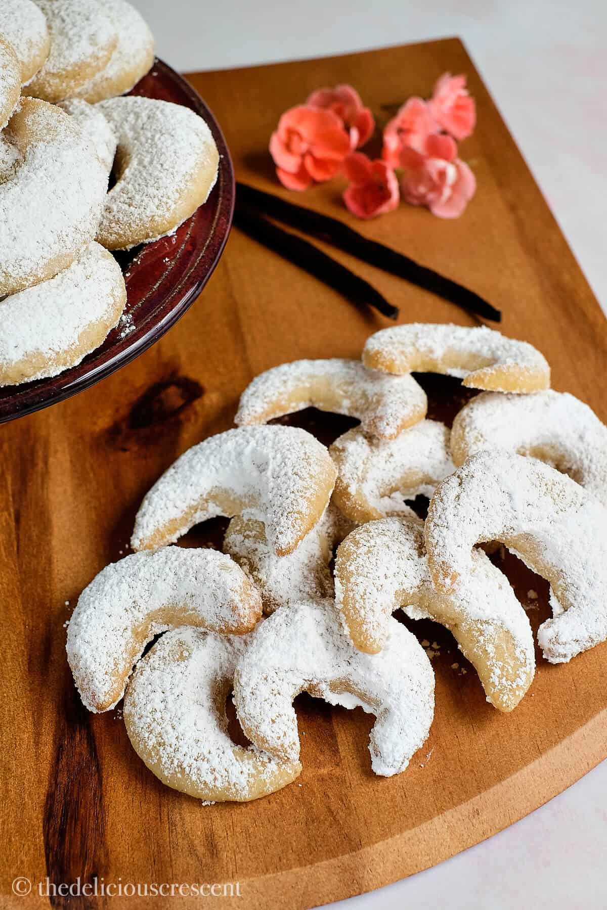 Vanilla crescent cookies on a wooden platter.