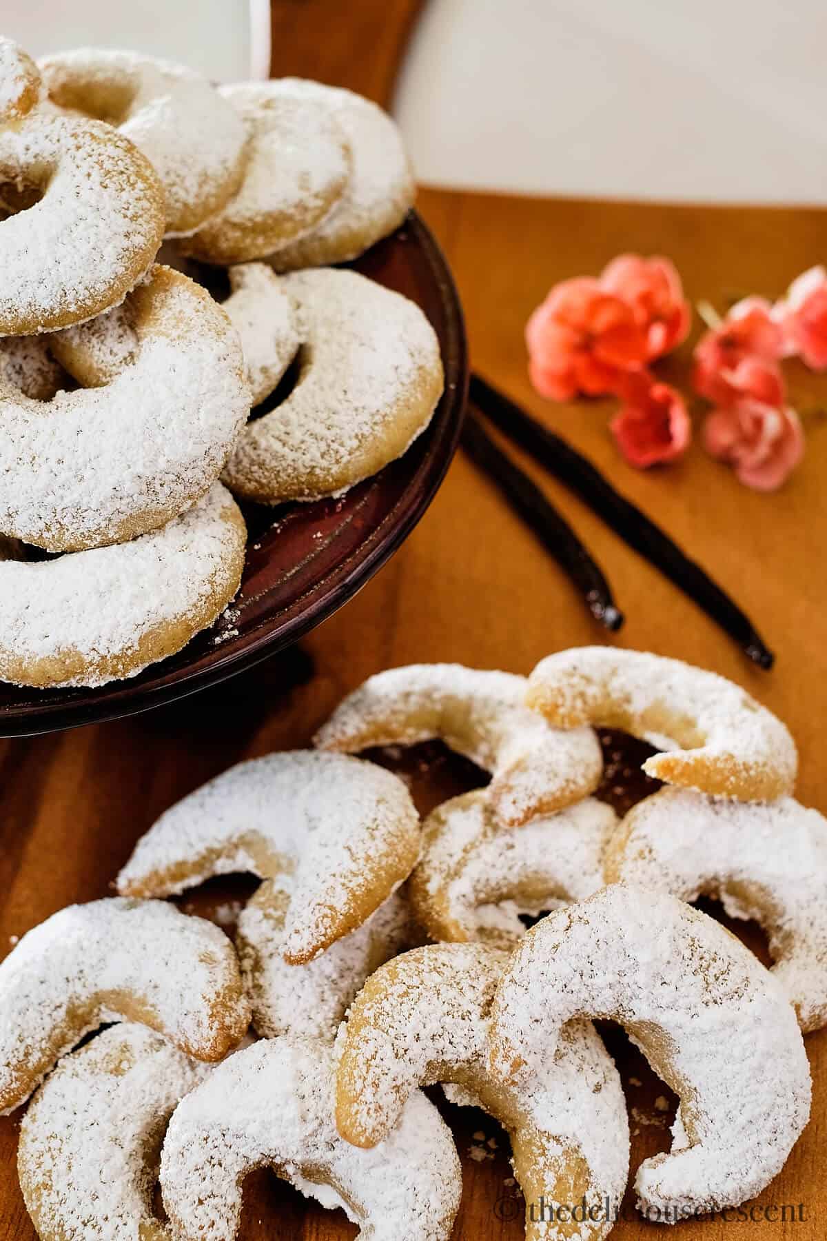 Vanillekipferl served in a bowl and on a wooden board.
