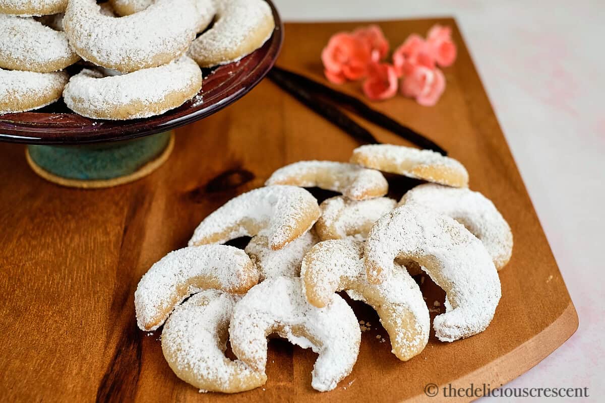 Vanillekipferl arranged on a wooden platter.