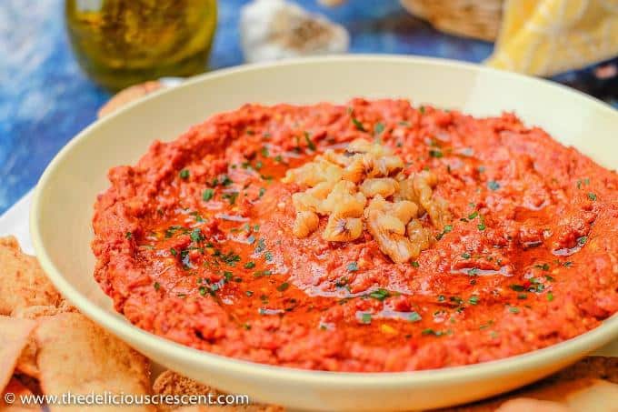 Close up view of muhammara, a roasted red pepper and walnut spread.