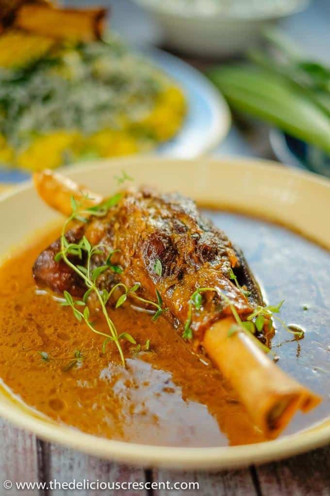 Persian braised lamb shanks served in a round serving dish with a fantastic sauce.