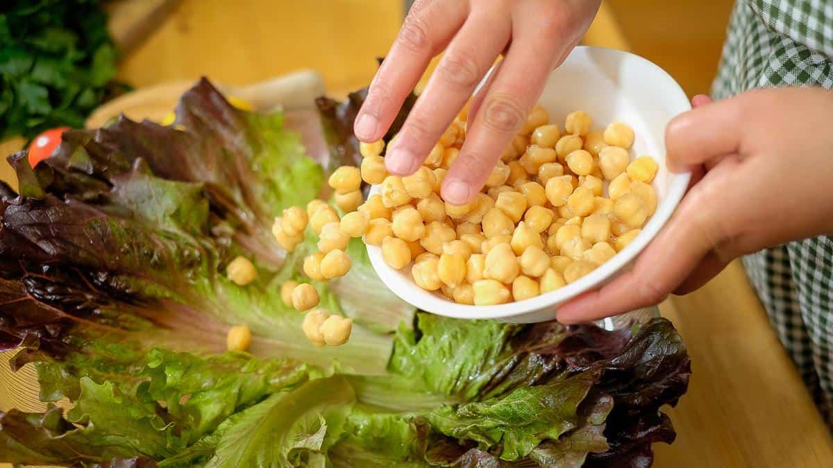 Adding cooked chickpeas to make salad.