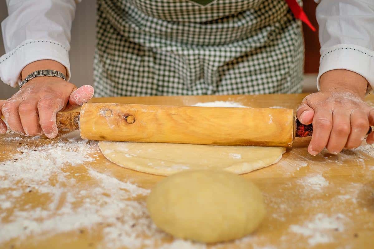Blog author rolling out the dough using a rolling pin.