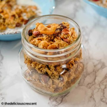 Homemade granola with cashews and cardamom stored in a glass bottle.