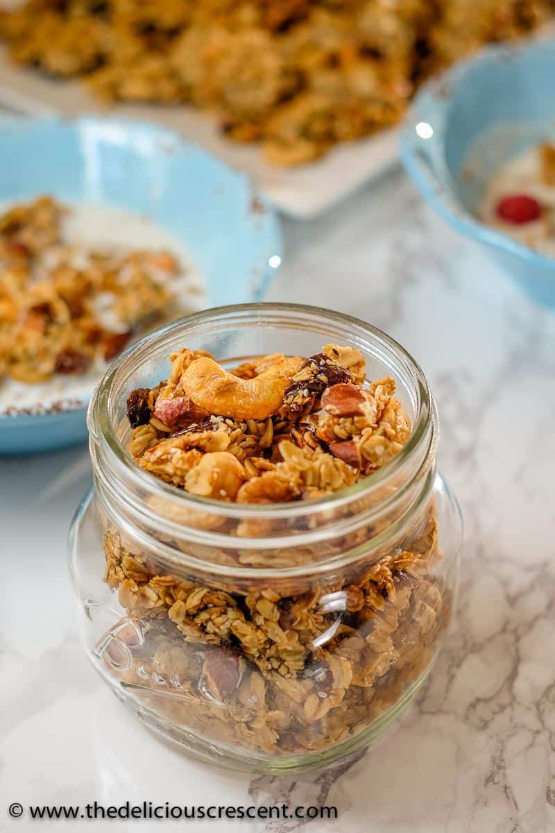 Homemade granola with cashews and cardamom filled in a glass bottle.