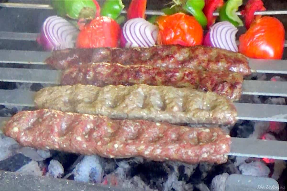 Picture showing koobideh in various stages of grilling.