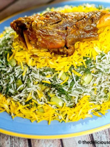 Baghali polo (dill rice with lima beans) served with a lamb shank on a plate.