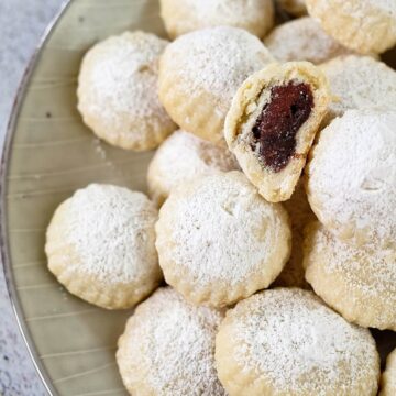 Close view of maamoul cookies dusted with powdered sugar.