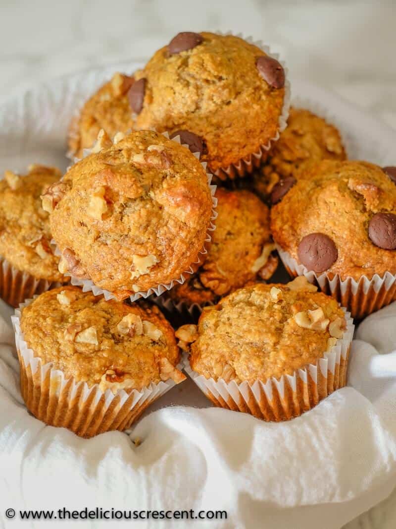 A bunch of banana bread muffins arranged in a white basket.