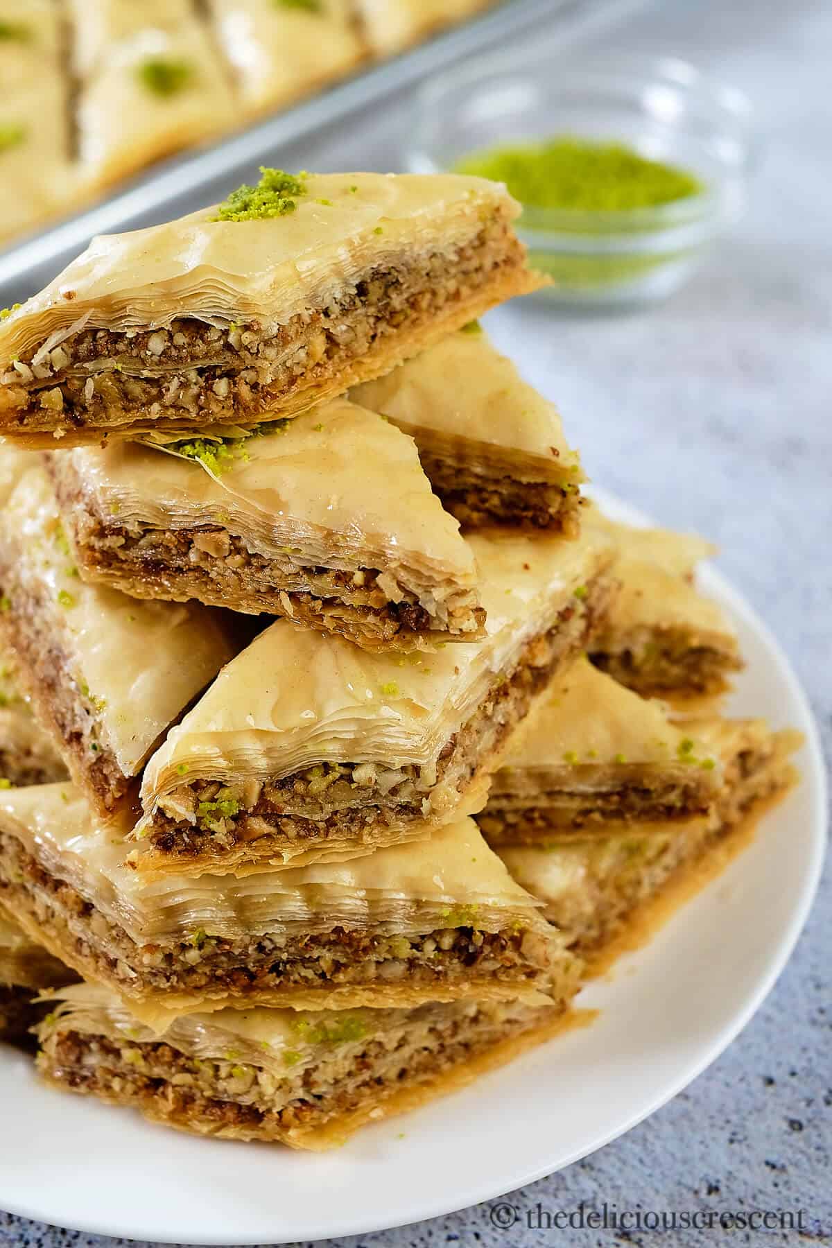 Baklava made with walnuts, almonds and honey served on a plate.