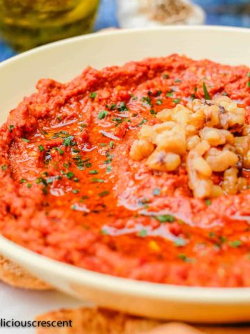 Muhammara served in a bowl with extra olive oil.