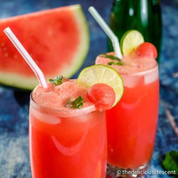 Watermelon juice with mint and lime slices served in glasses.