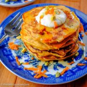Carrot pancakes stacked and served on a plate.