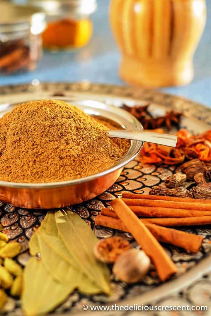 Homemade garam masala filled in a small bowl and placed on a decorative platter with spices.