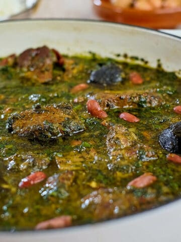 Close up view of Persian herb stew in a white pan.