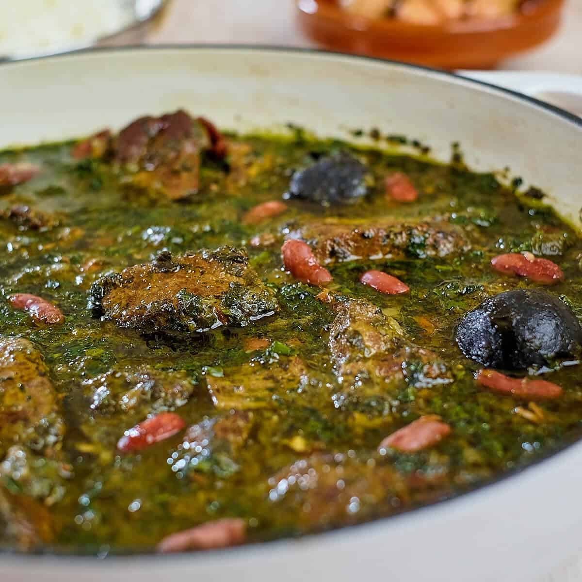 Close up view of Persian herb stew in a white pan.