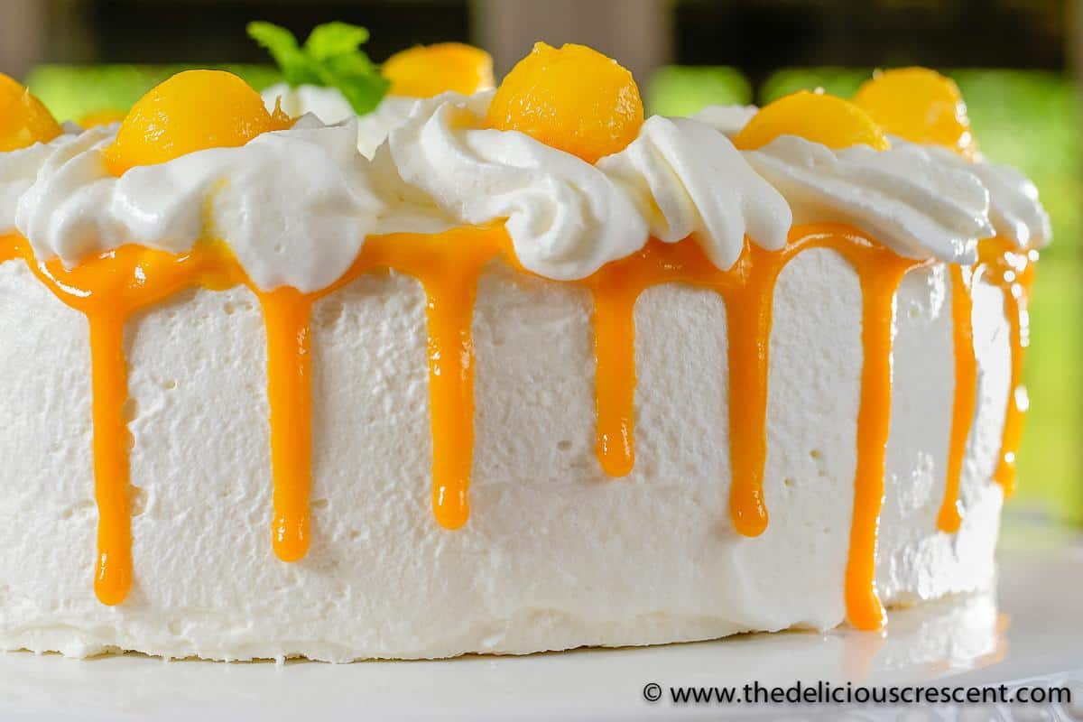 Whipped cream cake showing the mango puree drip decoration.