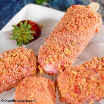 Strawberry shortcake ice cream pops served on a plate.