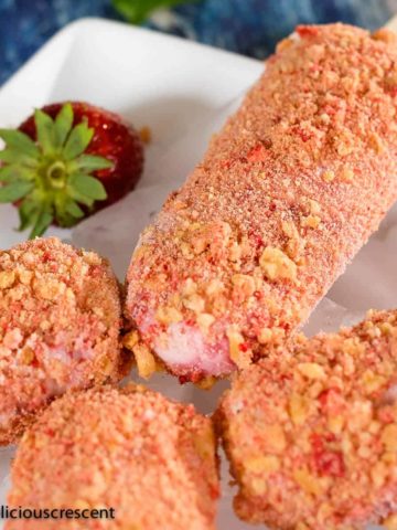 Strawberry shortcake ice cream pops served on a plate.