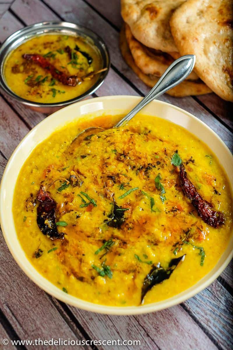 Delicious masoor dal with tadka served in a bowl and placed on a table.