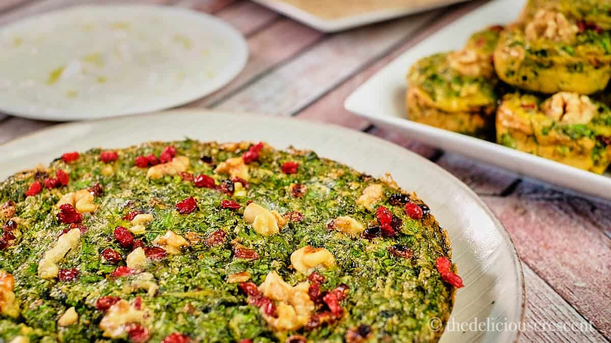 Persian herb frittata in traditional and appetizer muffin style placed on a table.