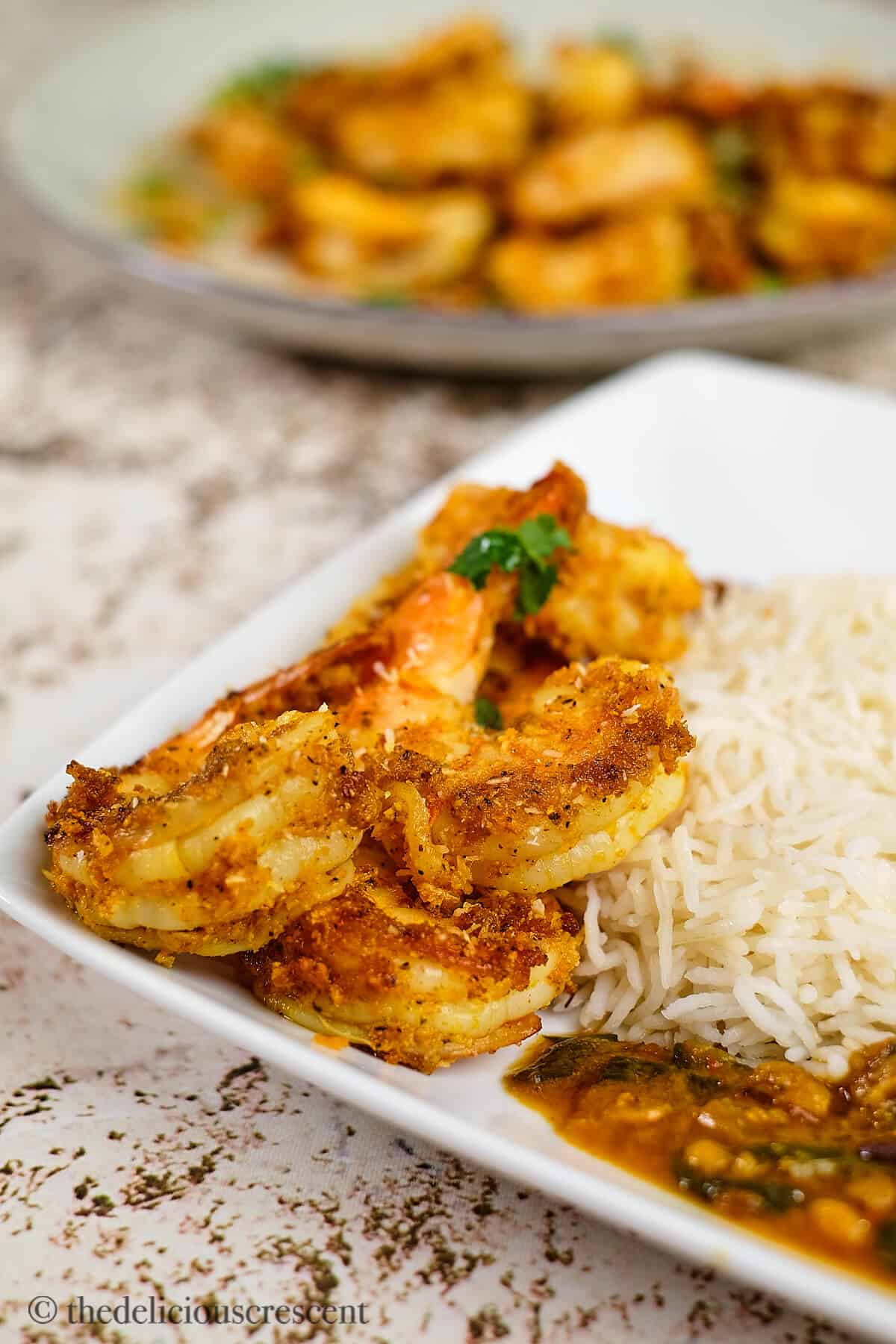 Masala shrimp served with rice and dal.