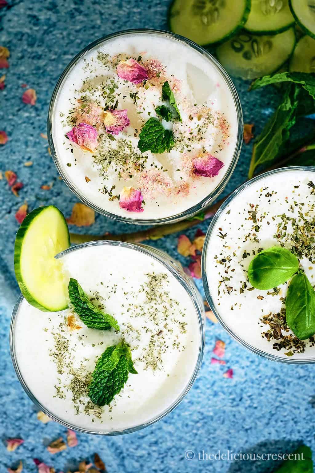 Overhead view of yogurt based beverage topped with herbs and rose petals.