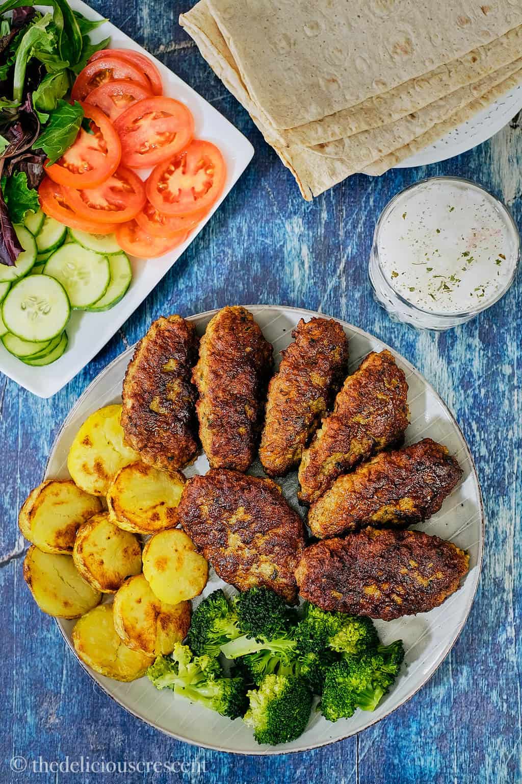 Overhead view of several Persian kotlets arranged on a plate and placed on a table.