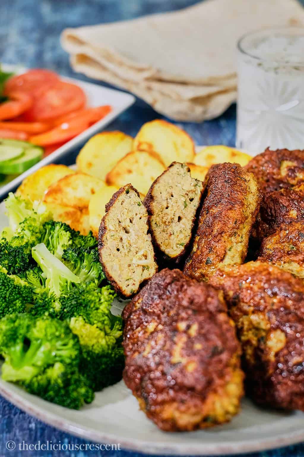 Close up view of meat patties with sides.