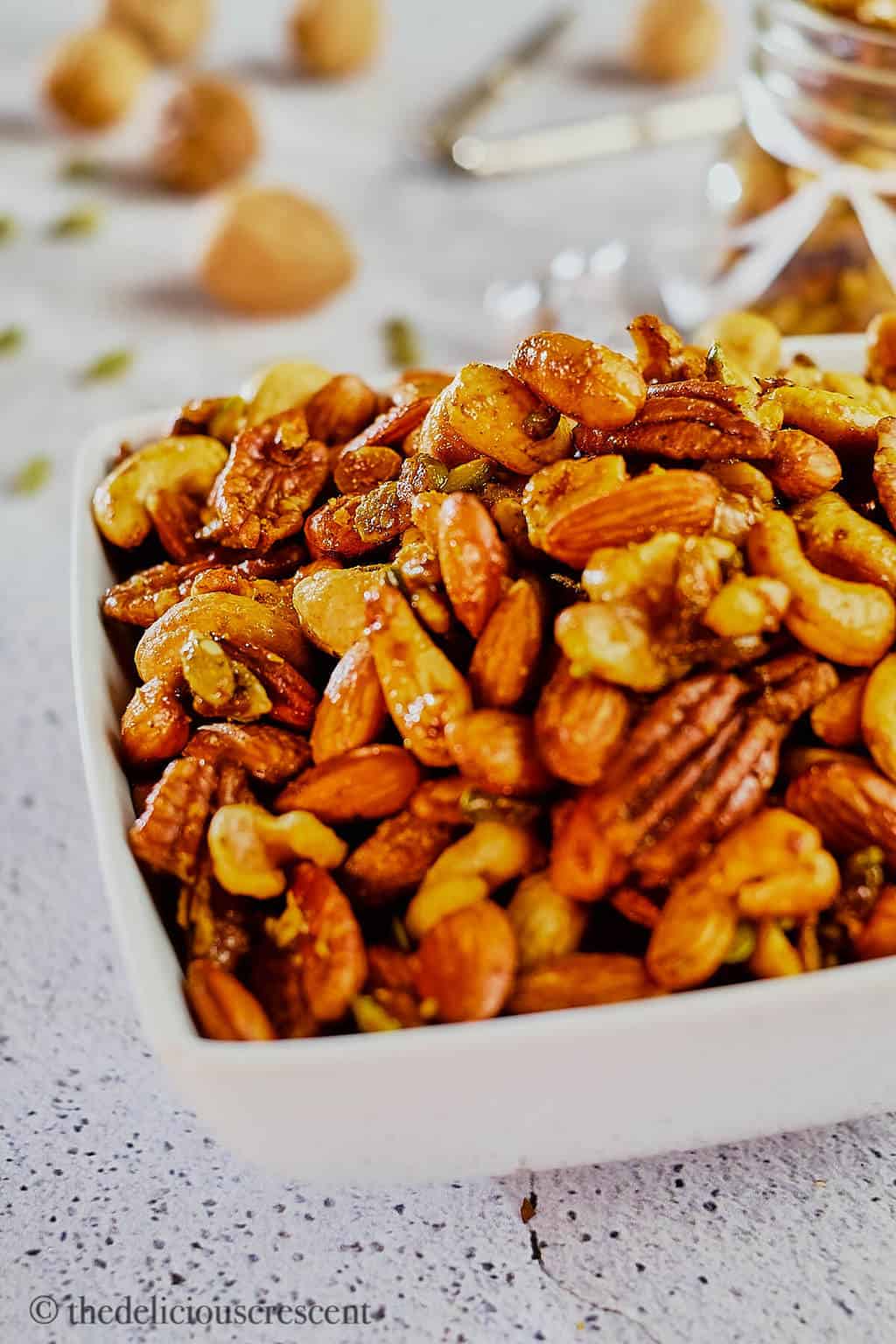 A white bowl full of sweet and savory roasted party nuts.