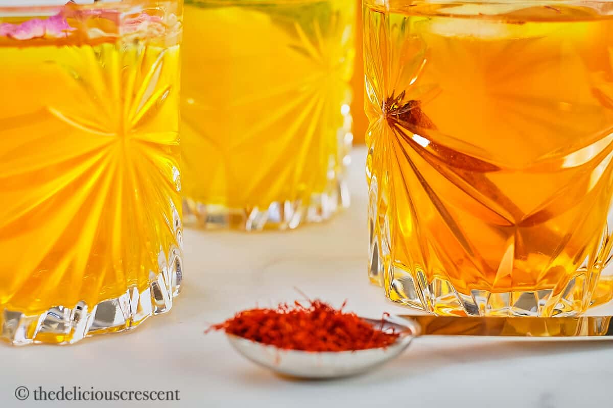 Iced saffron tea with different flavor variations served in clear glasses.