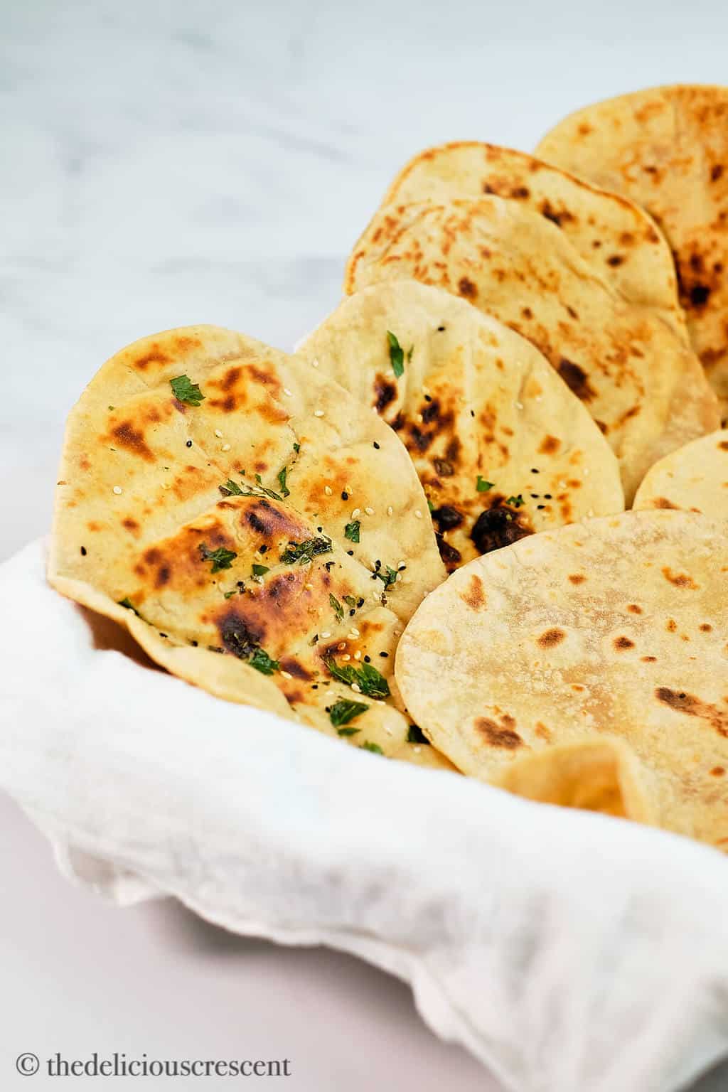 Side view of naan and other breads made in a skillet.