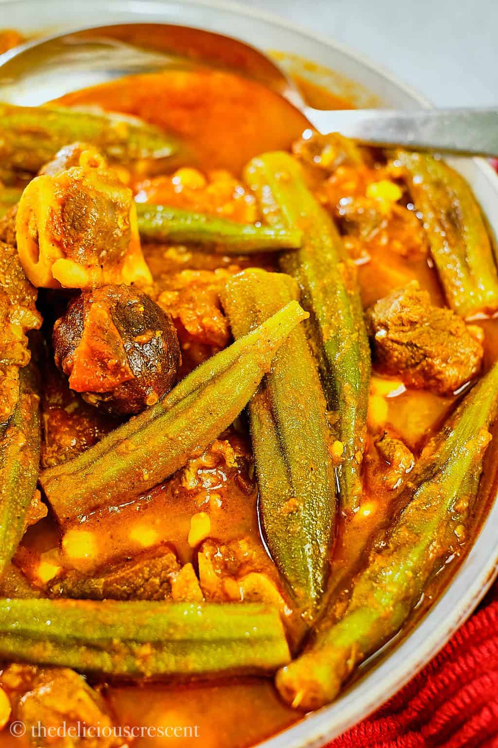 Close up view of okra stew in a serving bowl.