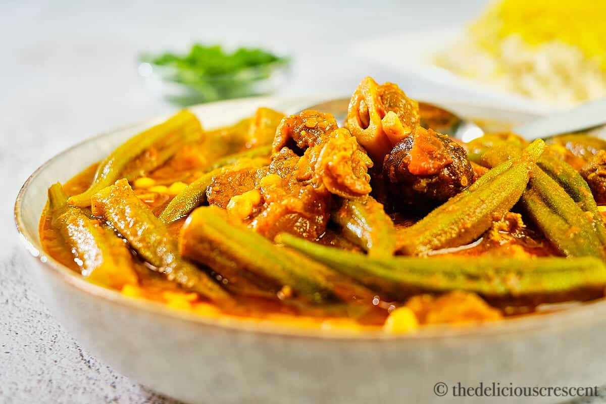 Front view of lamb stew cooked with okra in a tomato based gravy.