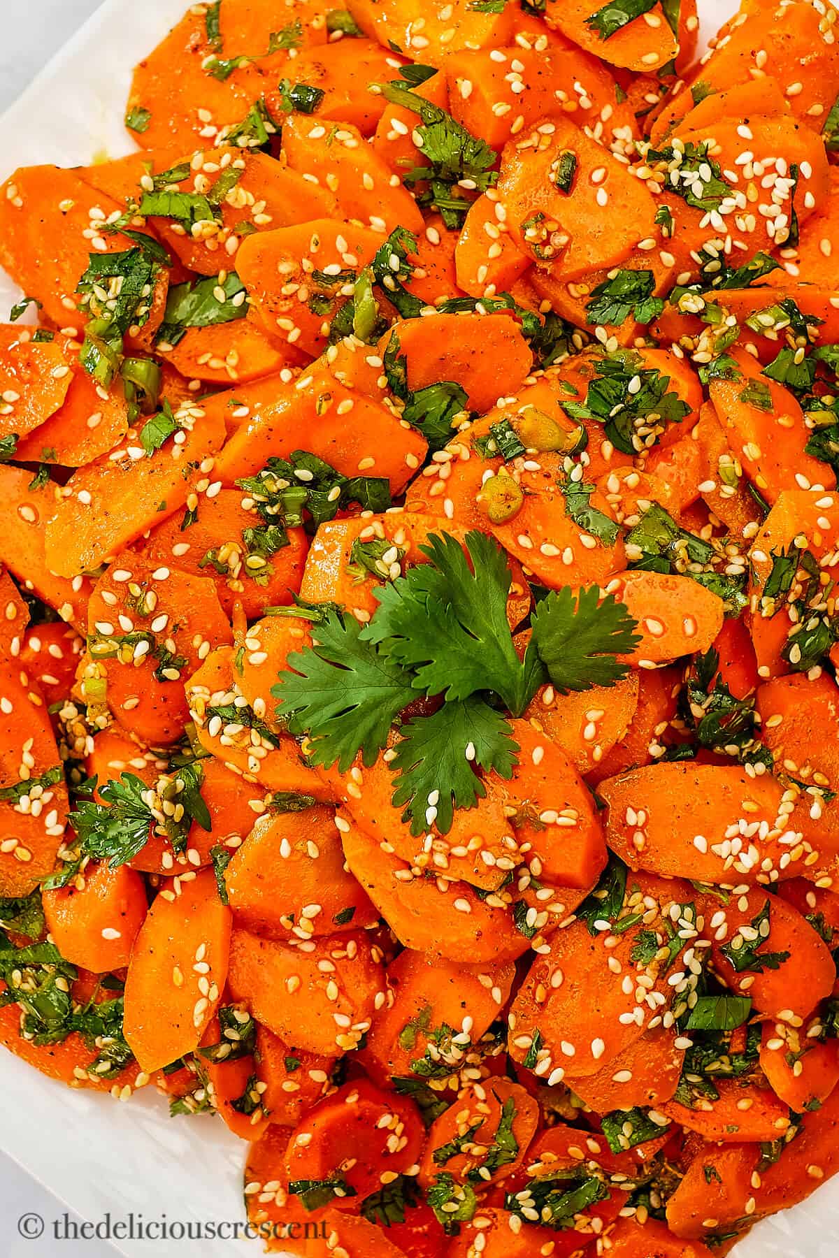 Spiced carrot salad garnished with herbs and sesame seeds.