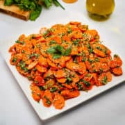 Spicy carrot side dish served in a white plate.