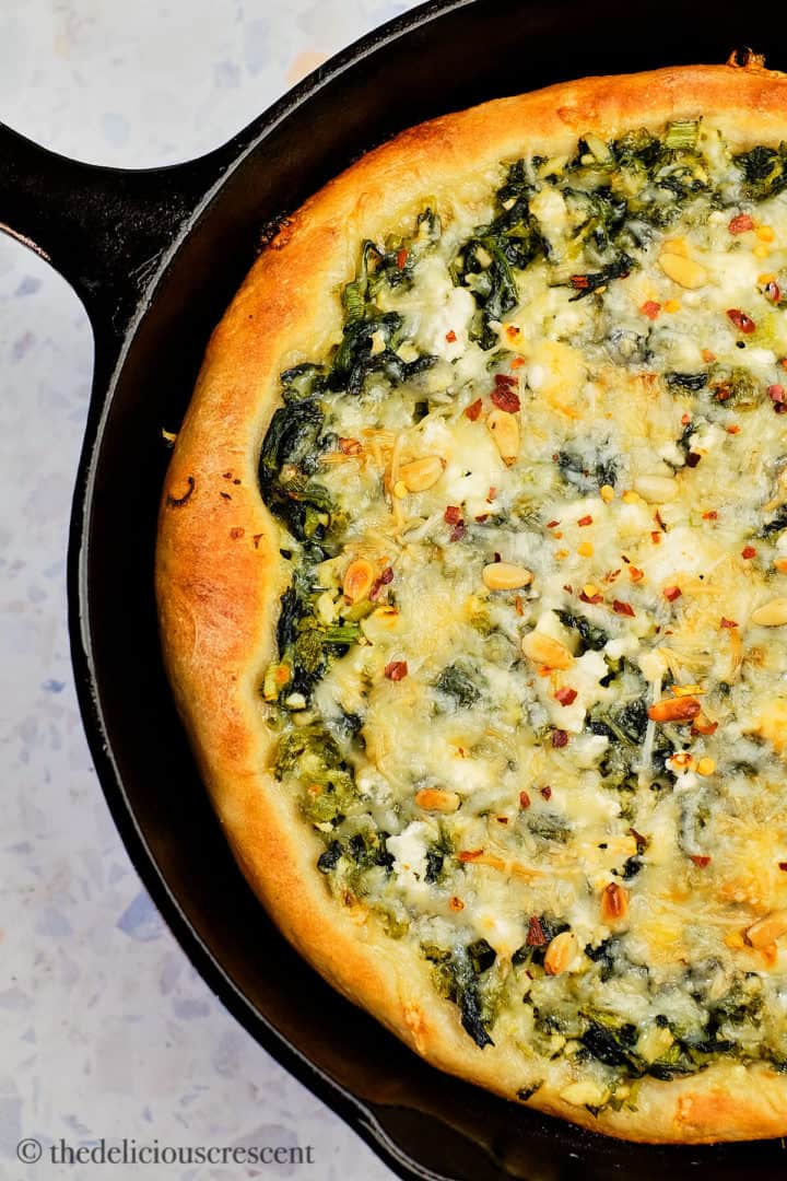 Spinach and feta cheese pizza made in cast iron skillet.