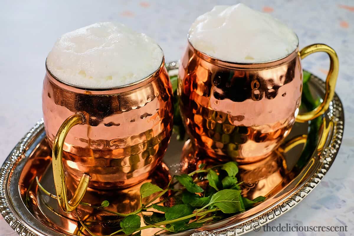 Two copper mugs with Turkish yogurt drink in it.