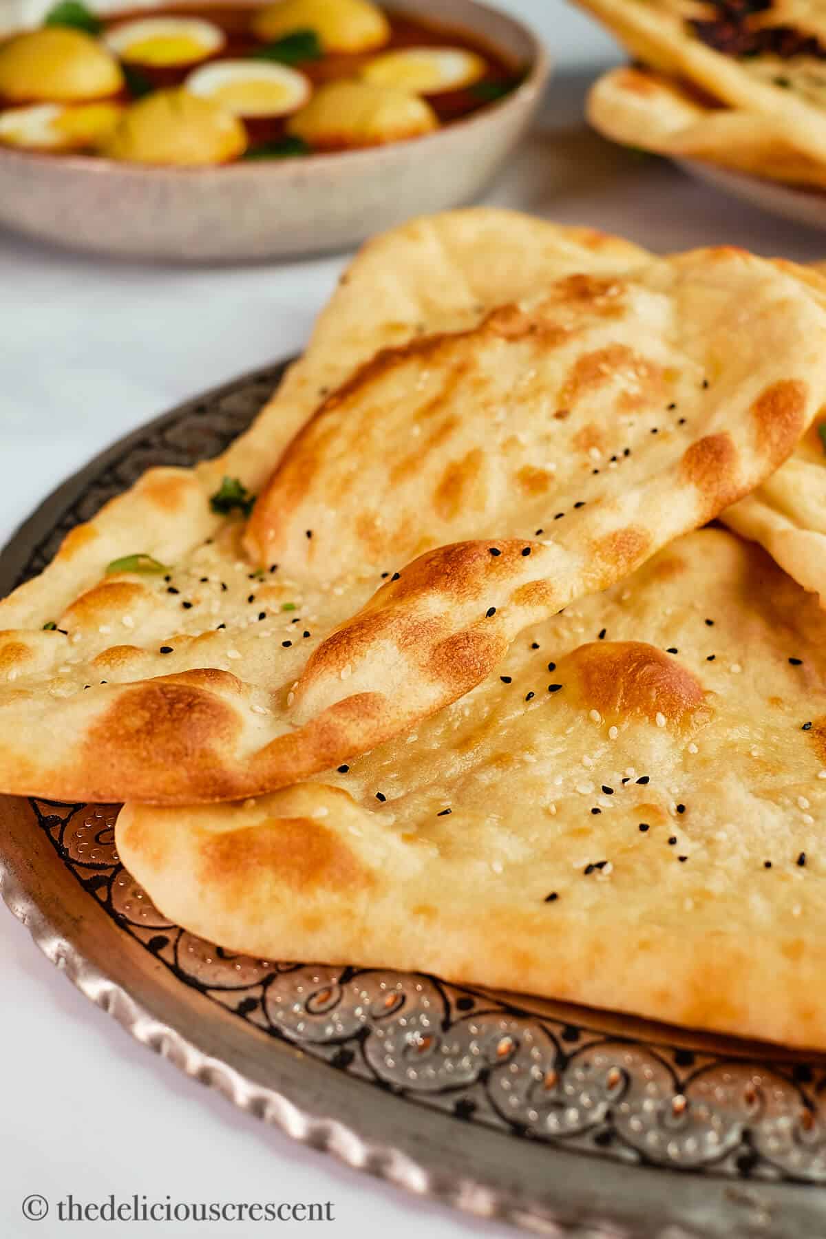 Flatbreads placed on a metal plate.