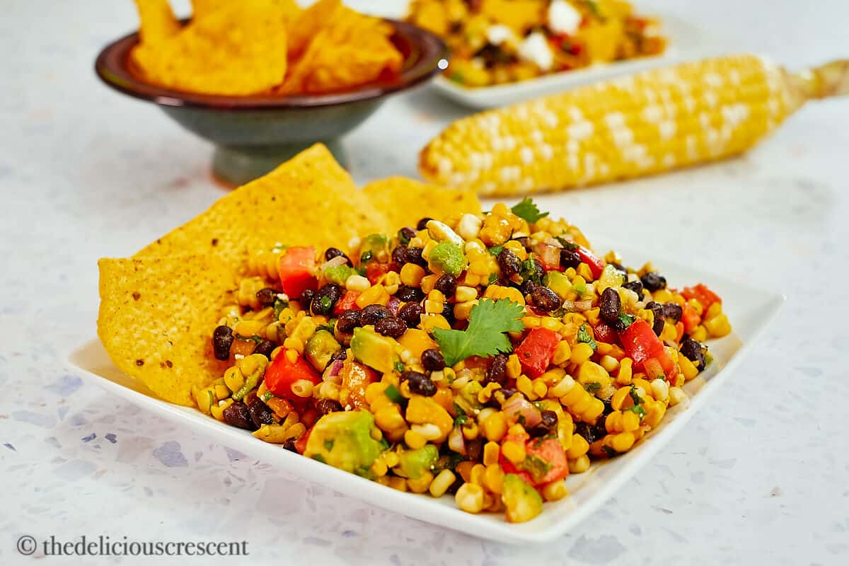 Corn and black bean salad served with corn chips.