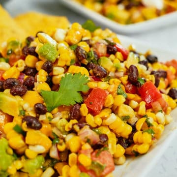 Spicy corn salad with avocado served on a plate.
